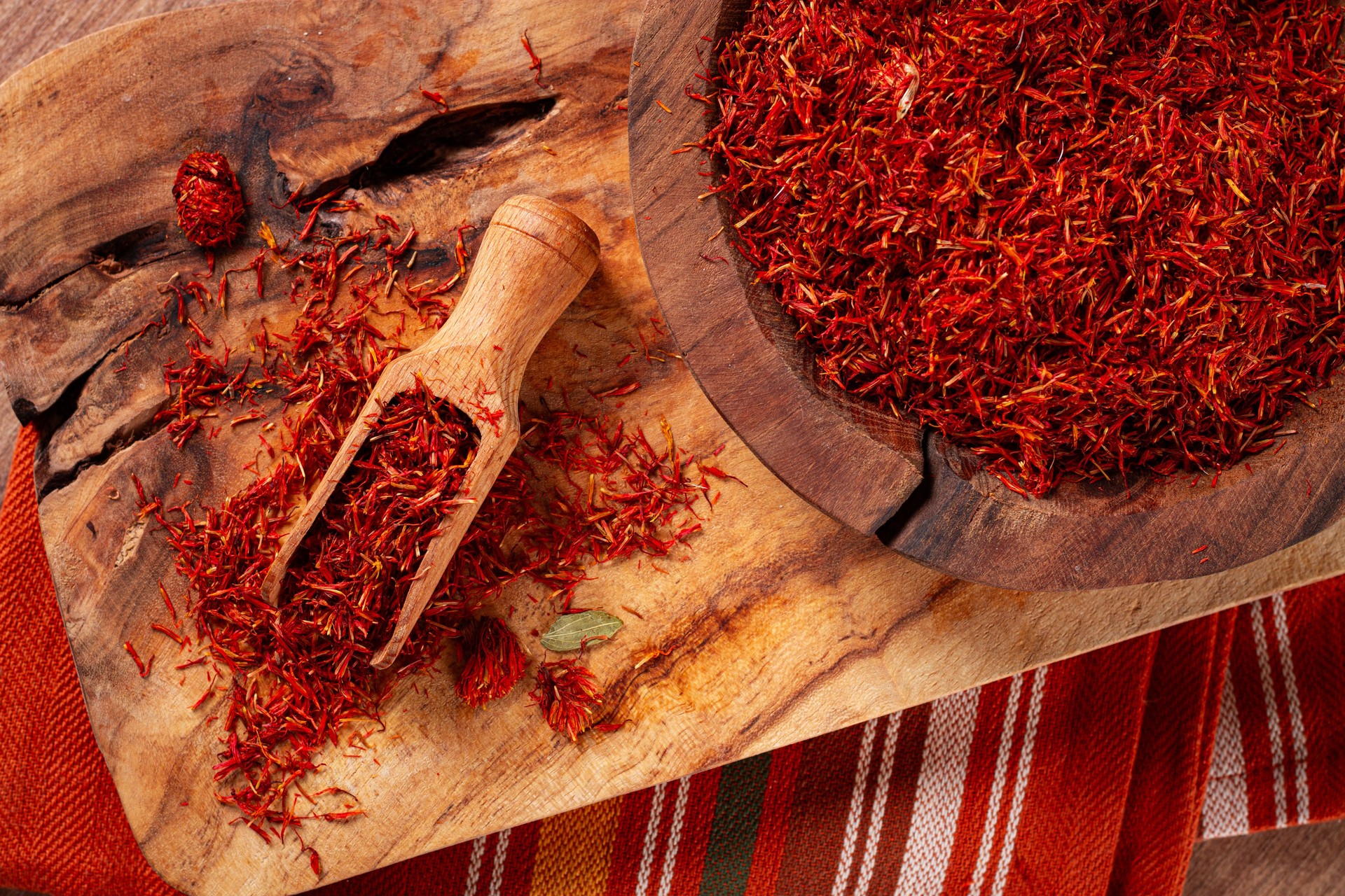 Spice saffron threads, in a wooden bowl, on a wooden table, top view, close-up,